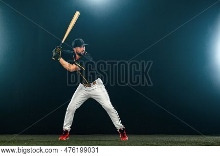 Baseball Player With Bat On Dark Background. Ballplayer Portrait.