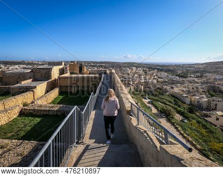 Rabat, Gozo, Malta - April 18, 2023: Woman Ealking On Fortified Walls Of Historical Citadel Ruins.
