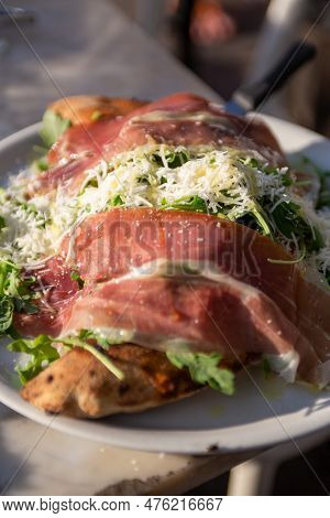A Big Proscuitto Calzone On A Plate Served