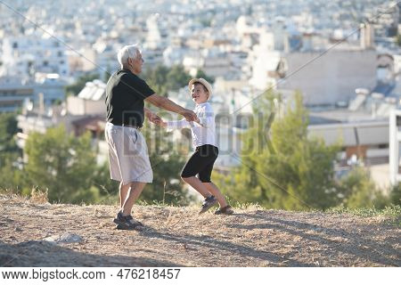 Old And Young. Family Generation And Relations Concept. Retired Grandfather And Grandson Playing Wit