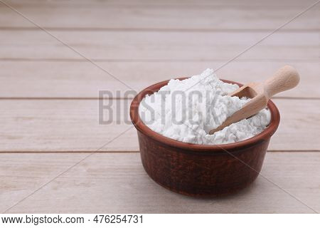 Bowl And Scoop Of Starch On Wooden Table, Closeup. Space For Text