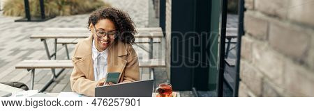 Afro American Woman Freelancer Working Remotely While Sittiing On Cafe Terrace