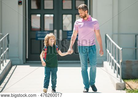 Father Walking Son To School. Parent And Pupil Of Primary School Schoolboy With Backpack. Parent Tak