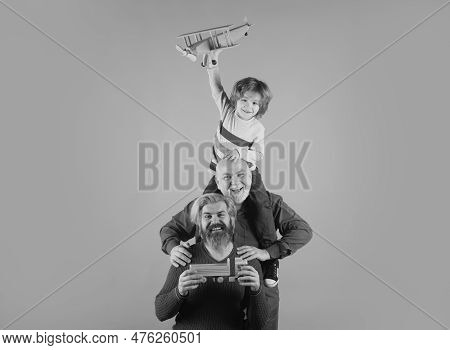 Boy Son With Father And Grandfather With A Toy Airplane Plays On Isolated Background.