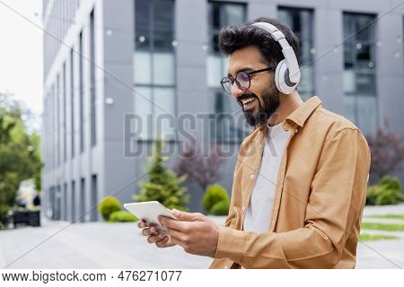 A Young Inus Man Walks Around The City In Headphones, A Businessman In A Shirt Watches An Online Vid