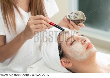Beautiful Woman Having A Facial Cosmetic Scrub Treatment From Professional Dermatologist At Wellness