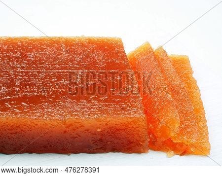 Piece Of Homemade Quince Jelly (carne De Membrillo). Typical Sweet Of Spain. Close-up On A White Bac