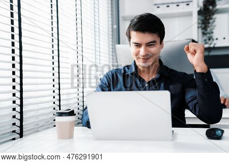 Young Male Employee Receives A Promotion, Good News Or Finished His Task And Overjoyed For Being A C