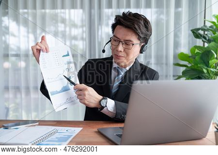 Confident Asian Telesales Businessman Work In Modern Office Wearing Headphone, Presenting Bi Dashboa