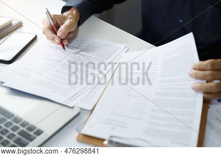 Asian Businessman Reviewing Document Reports At Office Workplace With Computer Laptop. Legal Expert,