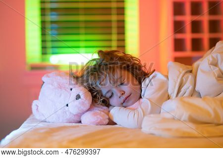 Nighttime Sleep. Kid Sleeps With A Toy Teddy Bear On Bed, Napping. Cute Child Sleeping.