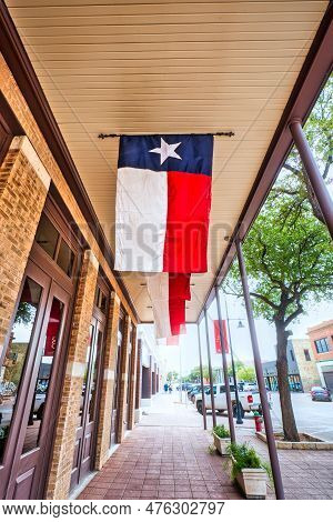 A Bustling Street In Abilene, Texas With The Exterior Of A Texas Star Trading Building Displaying A 