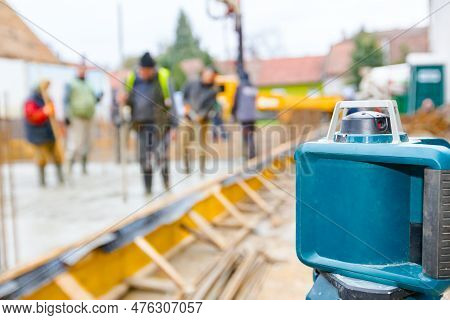 Total Center Device With Laser For Leveling Other Devices To Level Construction Site. Workers Measur