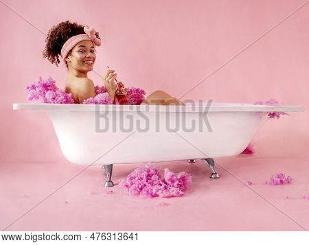 Attractive Young Female African With Terry Headband And Patches Under Her Eyes Is Sitting In Bath On