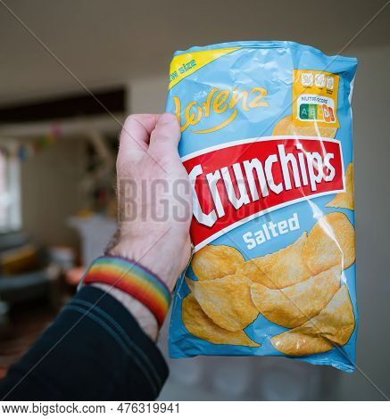 Paris, France - May 2, 2023: A Mans Hand Holds A Bag Of Lorenz Salted Crunchips, Ready To Enjoy Thei