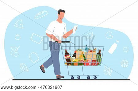 Young Man In Supermarket With Shopping List And Cart Full Of Groceries. Modern Male Character With T