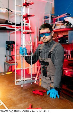 Engineer Or Technician Posing In Lab. Aircraft Capable Of Gps Surveillance. Look At Camera. Carbon.