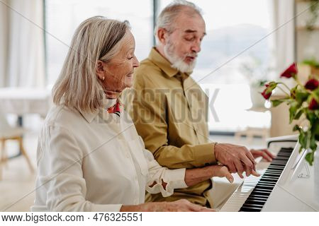 Senior Couple Playing On Piano Together At Home.