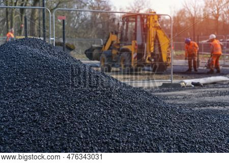 Asphalt Paver Filled With Hot Tarmac Laying New Road Surface On New Residential Housing Development 