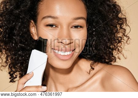 African American Woman With Ultrasound Scrubber Treating Her Skin For Remove Blackheads And Cleansin