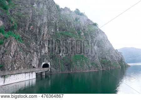 Vidraru Dam Lake In Romania . Foggy Scenery With Mountains And Lake . Vidra Lake  Valcea County Roma