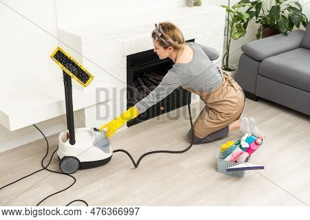 House Cleaning. Girl Brushes Steam Cleaners Kitchen White Electronic Parable Steam In Gloves. Cleani