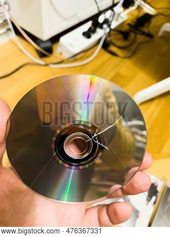 A Man Looks At A Compact Disk Audio Damaged During Transport