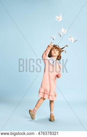Full-length Portrait Of Playful, Lovely Little Girl In Pink Dress Posing, Playing With Paper Birds A