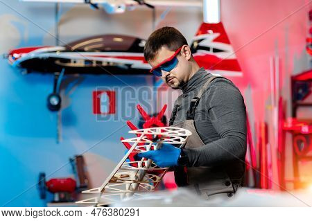 Young Male Engineer Or Technician Working On Drone Details In Lab. Aircraft Capable Of Gps Surveilla