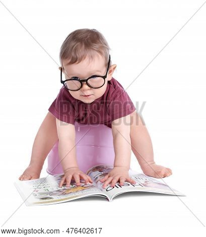 Little Child With Glasses And Book Sitting On Baby Potty Against White Background