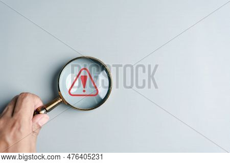 System Warning Caution Sign Inside Magnifier For Notification Error And Maintenance. Cyber Attack On