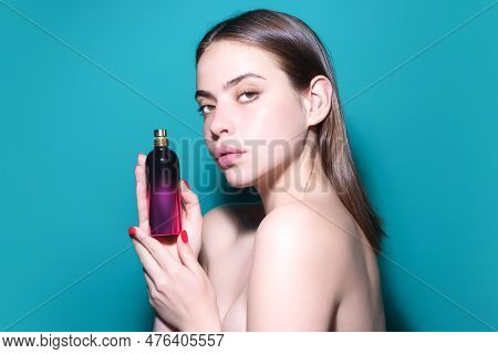 Young Pretty Woman Smelling Perfume. Sensual Woman With Bottle Of Perfume, Beauty Portrait. Female P