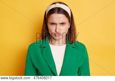 Offended Unhappy Angry Woman Wearing Green Jacket Posing Isolated Over Yellow Background Looking At 