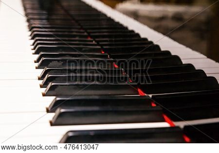 Black And White Piano Keys With A Reflection Of The Same Keys On The Piano Body, Close-up.