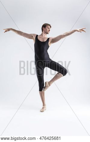 Caucasian Ballet Dancer Man Posing In Dancing Stretching Pose With Hands Lifted While Standing In Ba