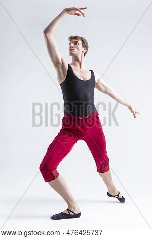 Tranquil Concentrated Contemporary Ballet Dancer Flexible Athletic Man Posing In Red Tights In Balla