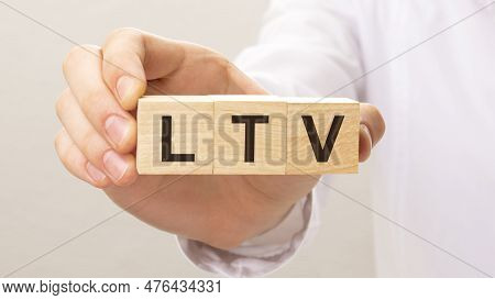 Wooden Cubes With The Letters Ltv On The Hand On The White Background