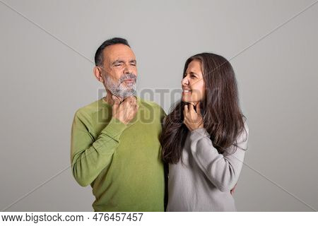 Sad European Old Couple Suffer From Sore Throat, Tonsillitis On Gray Studio Background