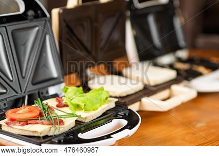 A Variety Of Sandwiches That Can Be Prepared In A Sandwich Maker Concept. Row Of Electric Sandwich M