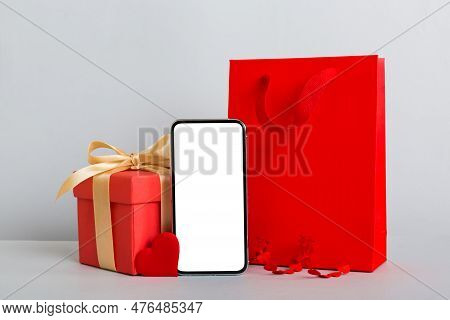 Mobile Phone With Blank Screen On Colored Background With Hearts, Calendar And Gift Box, Valentine D