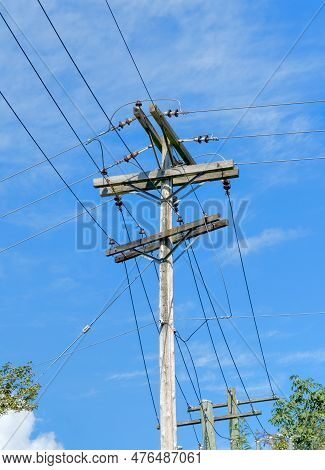 Electric Pole And Wires, Wood Electricty Pole On Blue Sky Background.