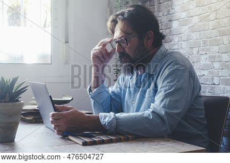 Mature Man At Work With Difficult To Read On Laptop Screen Adjust Eyewear And Stress Eyes Sight. Agi