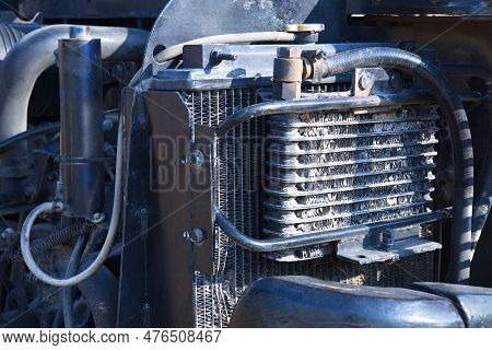 Intercooler In Front Of The Radiator. Closeup Of Old Excavator Turbo Intercooler Panel In Front Of O