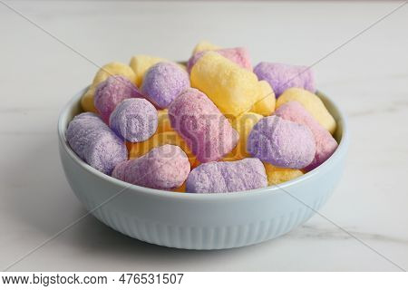 Bowl With Colorful Corn Puffs On White Marble Table, Closeup