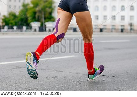 Legs Female Runner Athlete Running Marathon In City, Compression Socks On Feet, Kinesiotaping On Kne