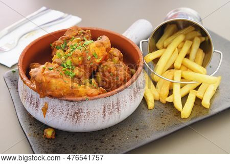 Tasty Spicy Rabbit Stew In Tomato Sauce With French Fries As A Side Dish In A Nicely Plated Arrangem