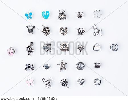 A Variety Of Metal Charms For A Child's Necklace Or Bracelet. Many Charms Isolated On A White Backgr