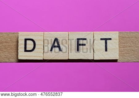 Word Daft From Small Gray Wooden Letters Lies On A Purple Background
