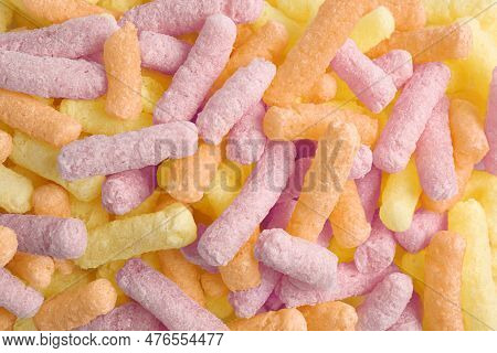 Many Colorful Corn Puffs As Background, Top View