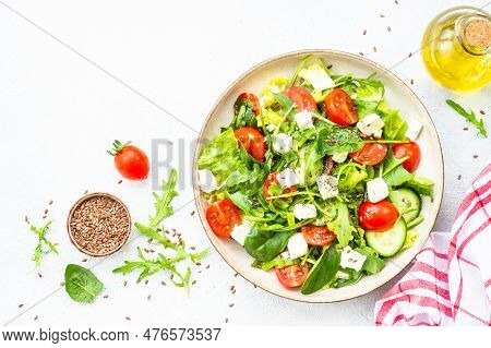 Green Salad With Spinach, Arugula, Tomatoes And Feta With Olive Oil. Top View On White.
